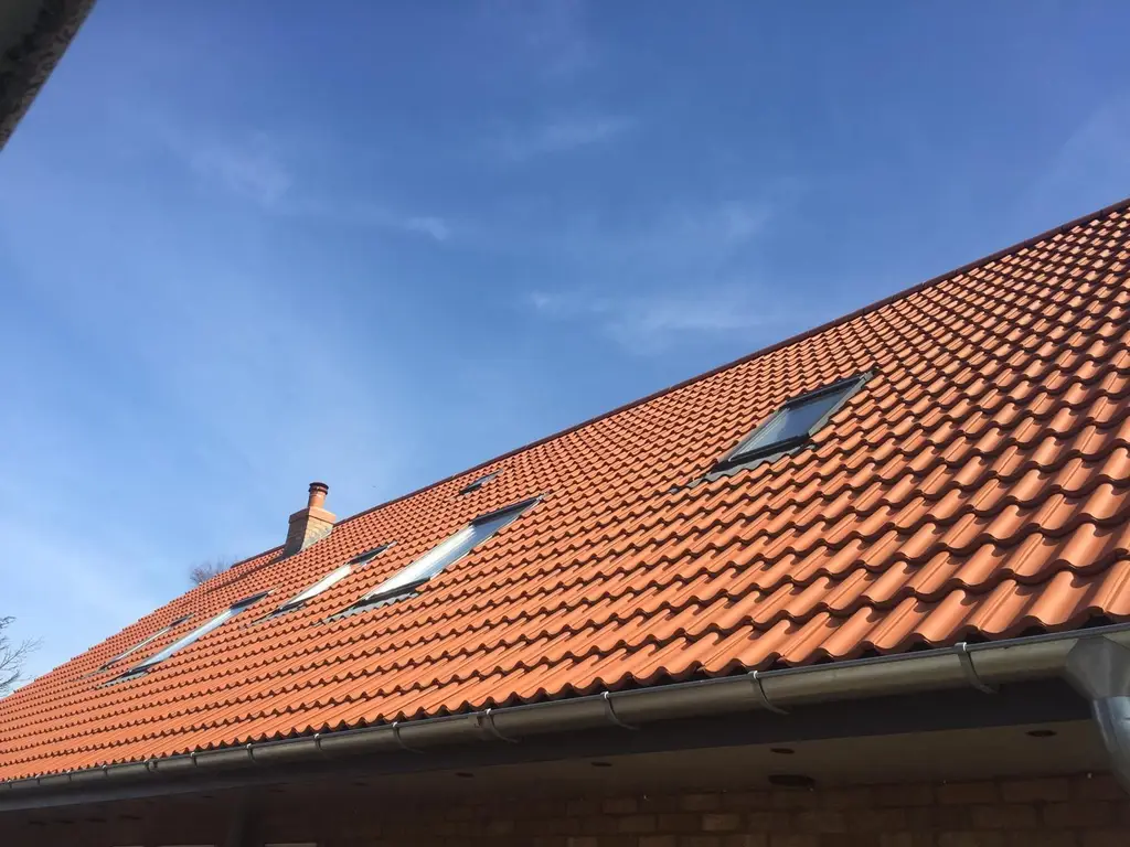 Red tiled roof with three roof windows by Carl Dunn Building & Roofing, Cambridge