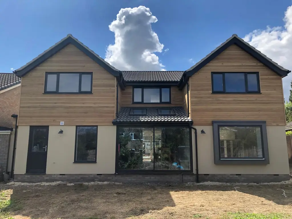 Two storey house with timber cladding and new windows by Carl Dunn Building & Roofing, Cambridge